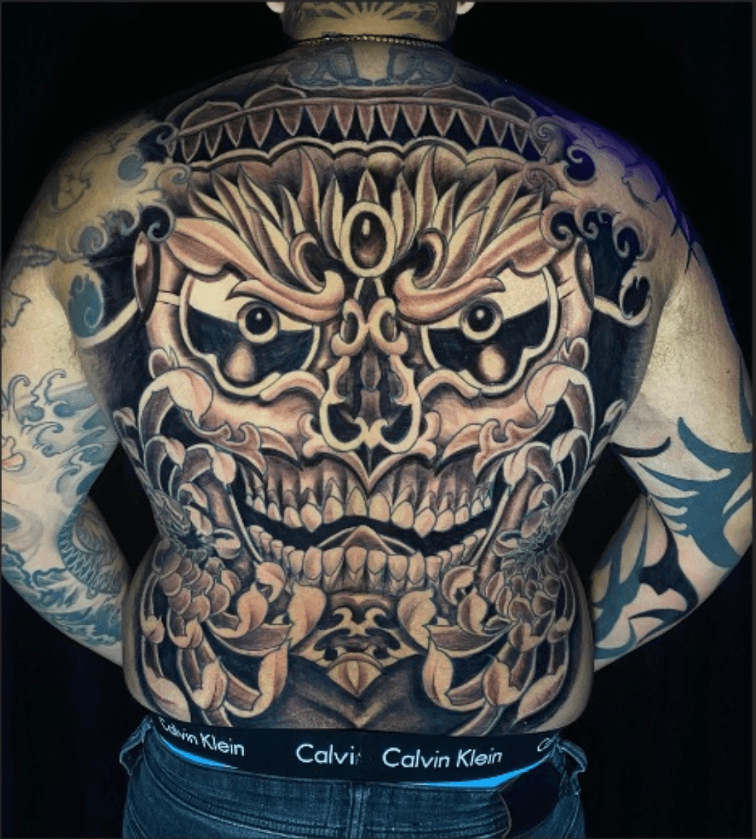Intricate Full Back Custom Tattoo featuring a demonic mask or deity